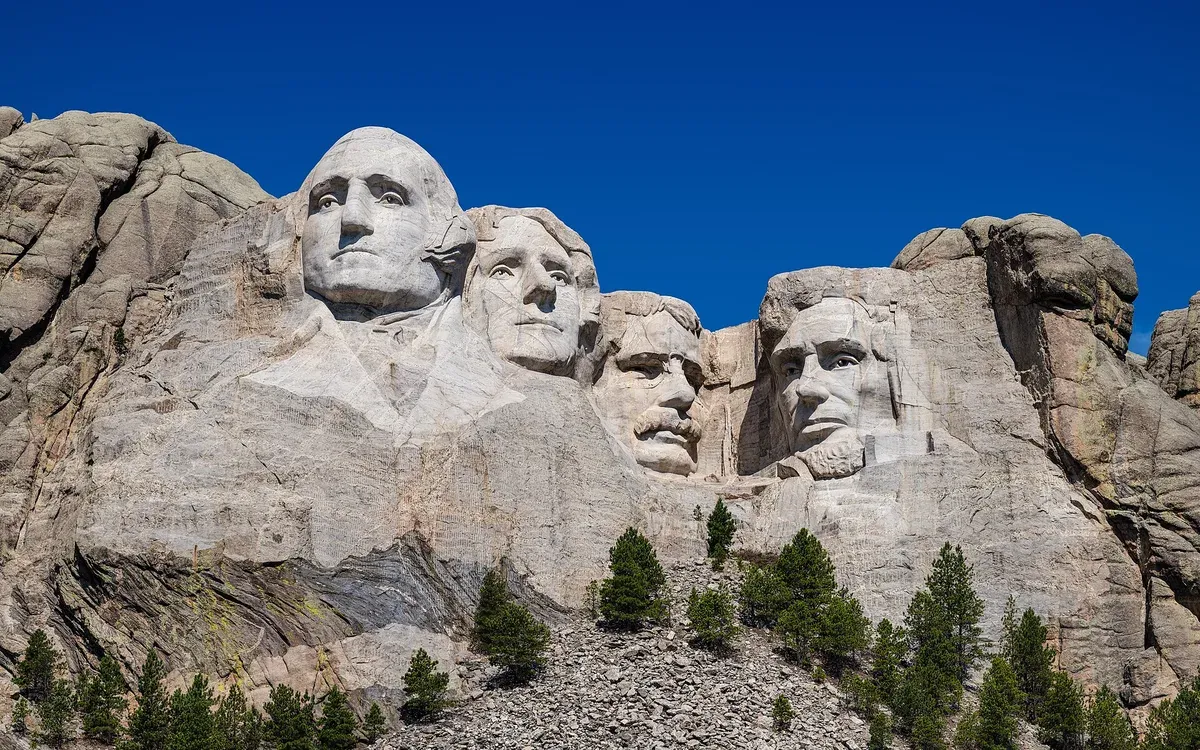 The four presidential faces of Mount Rushmore under a deep blue sky