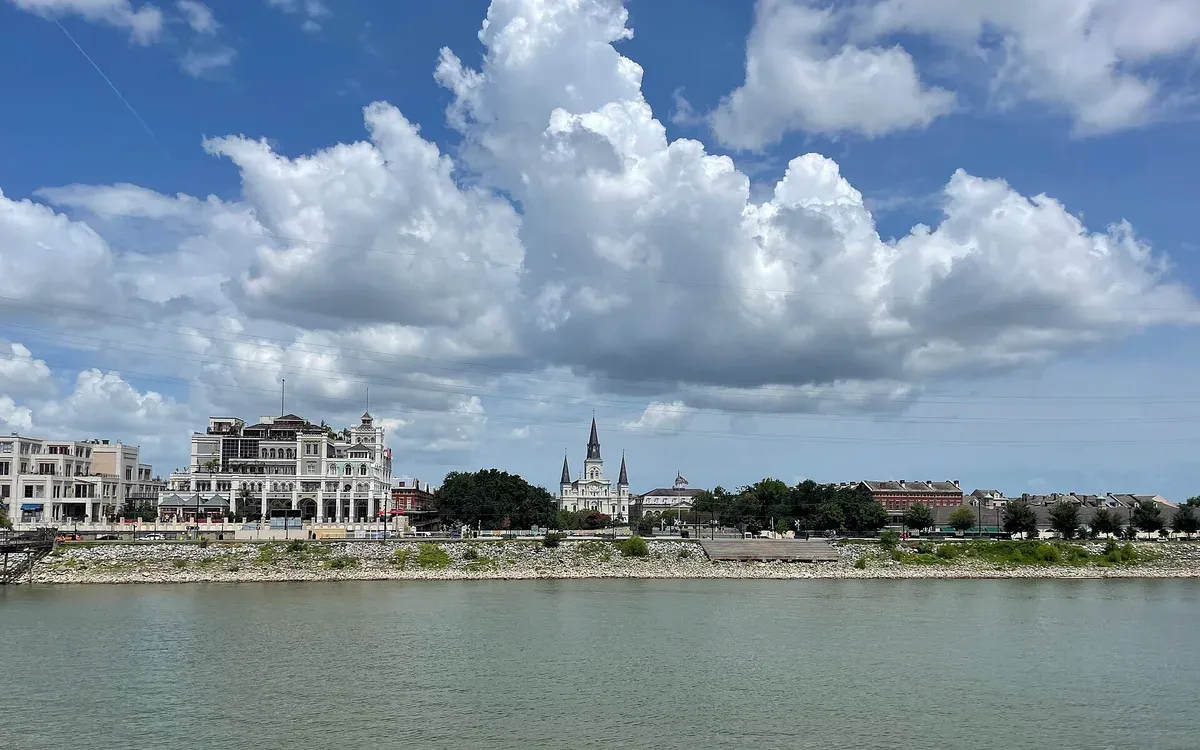 The Jackson Square and French Quarter riverfront skyline, including the spires of St. Louis Cathedral, viewed across the Mississippi River in New Orleans