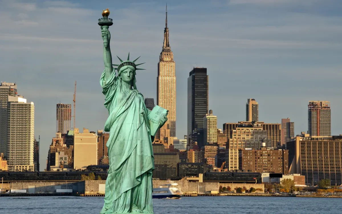 The Statue of Liberty with the Empire State Building and the Manhattan skyline behind