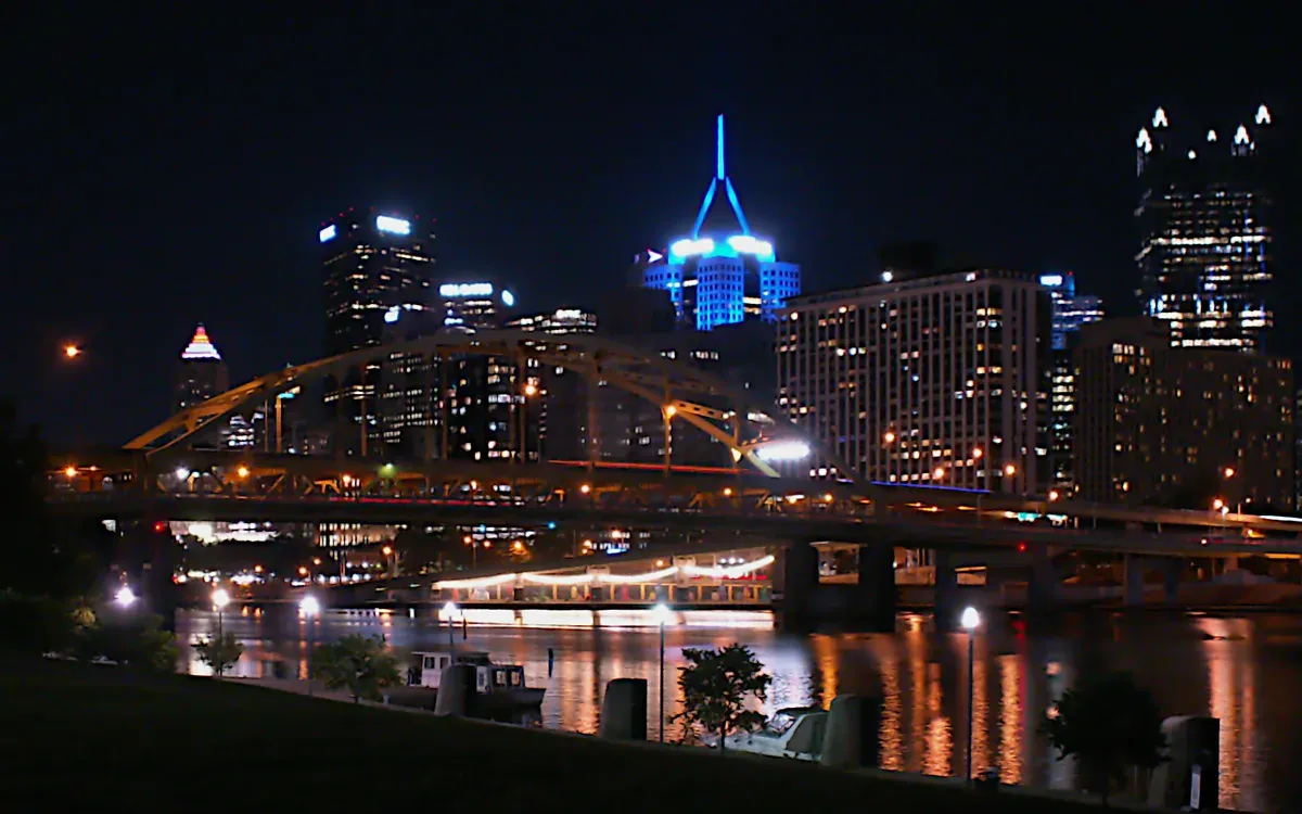 The downtown Pittsburgh skyline lit up at night, seen from the North Shore across the Allegheny River