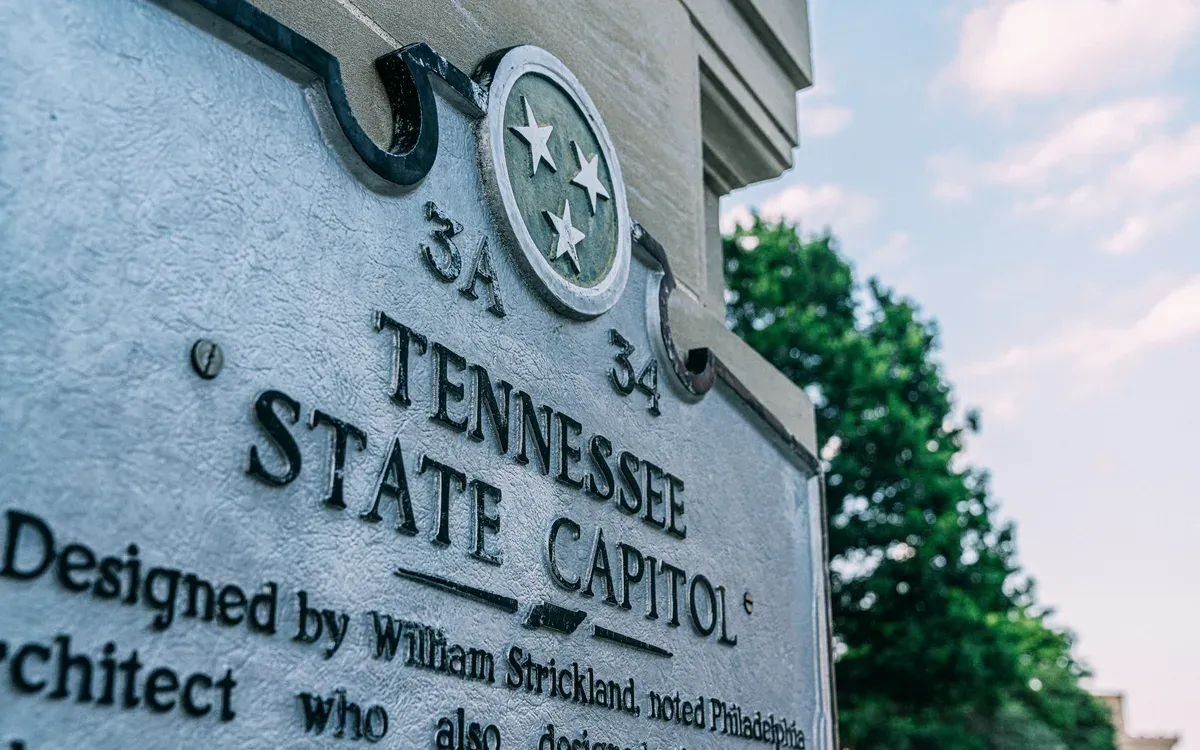 The historical marker at the Tennessee State Capitol in Nashville, with the tri-star state emblem