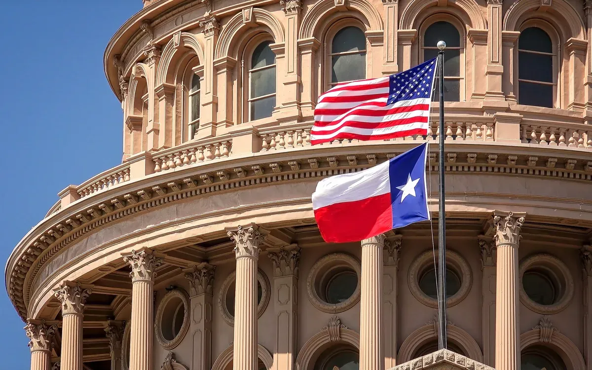 The Texas State Capitol dome in Austin with the United States and Texas flags flying